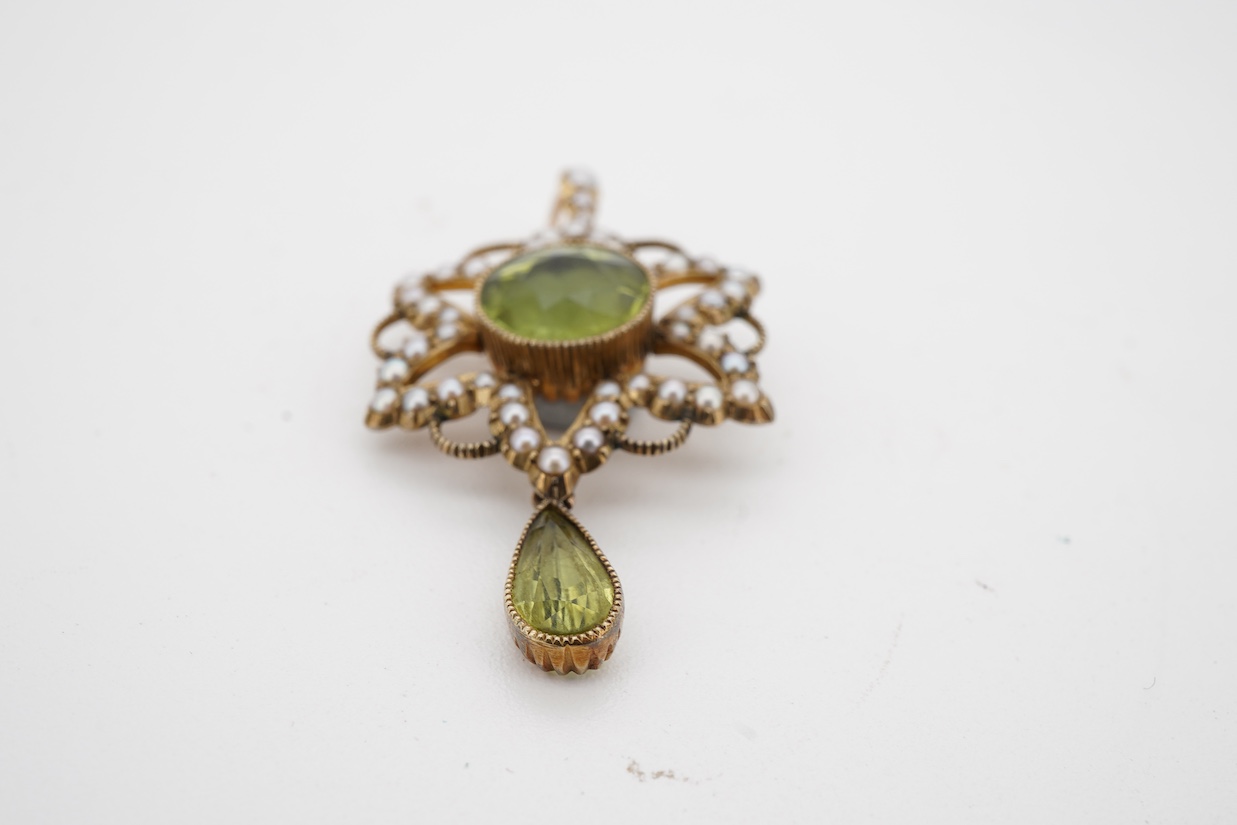 An Edwardian 15ct, peridot and seed pearl cluster pendant, set with circular and pear cut peridot, overall 39mm.